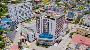 A multi-story hotel with a modern design, featuring a prominent glass facade and a rooftop terrace. - Hoa Dao Hotel (Hoa Binh)