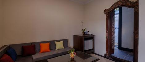 A living room with a sofa, a coffee table, and a decorative mirror.