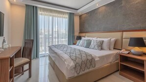 A modern hotel room with a large bed, a desk, and a chair. - Dun Gorg Guest House (Marsaxlokk)