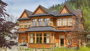 Une grande maison en bois avec de nombreuses fenêtres et un balcon.