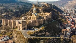A historic fortress with a church on a hill overlooking a town. - BARNOVI BOUTIQUE HOTEL (Tbilisi)