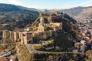 A historic fortress with a church on a hill overlooking a town. - BARNOVI BOUTIQUE HOTEL (Tbilisi)