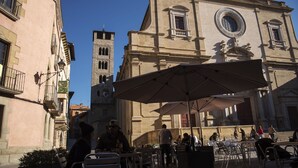 A plaza with outdoor seating and a historic building with a clock tower. - Hotel J. Balmes Vic (Vic)