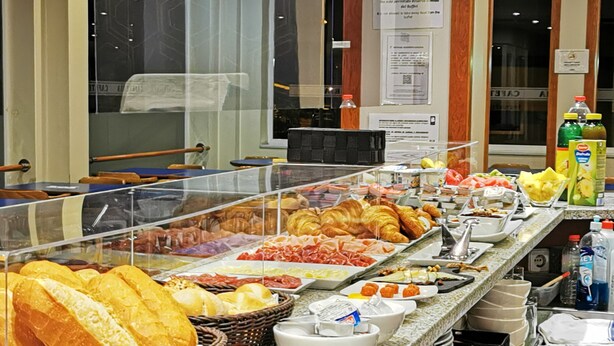 A buffet with various food items including bread, pastries, and meats. - Hotel J. Balmes Vic (Vic)
