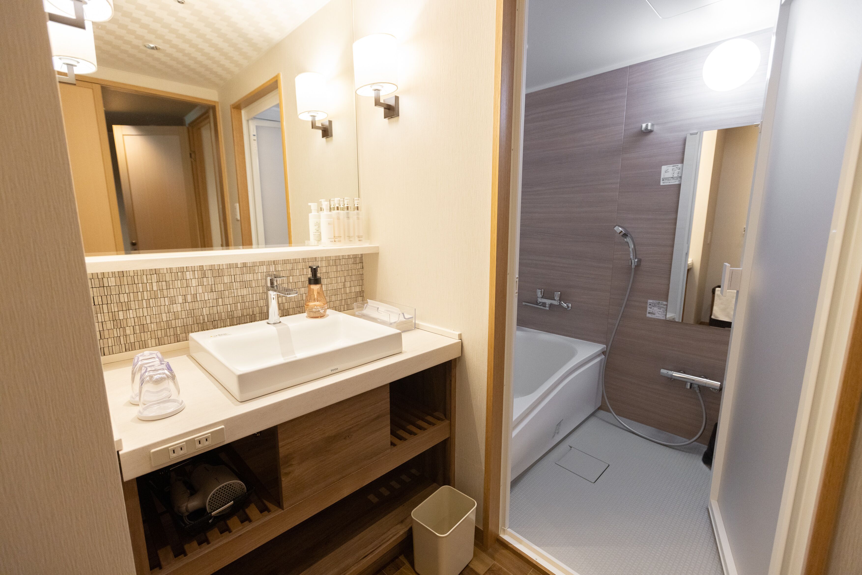 A modern bathroom with a white sink, mirror, and shower.
