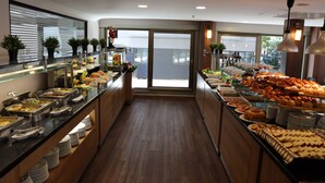 A buffet with various food items and a view of the outdoors through a glass door. - Riva Hotel Taksim (Istanbul)