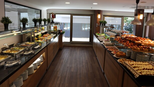 Un buffet proposant une variété de plats, avec une vue sur l’extérieur grâce à une porte vitrée.