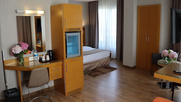 A hotel room with a bed, a desk with a computer, a TV, and a wardrobe. - Riva Hotel Taksim (Istanbul)