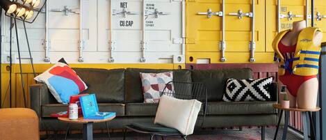 A modern living room with a sofa, a coffee table, and a mannequin.