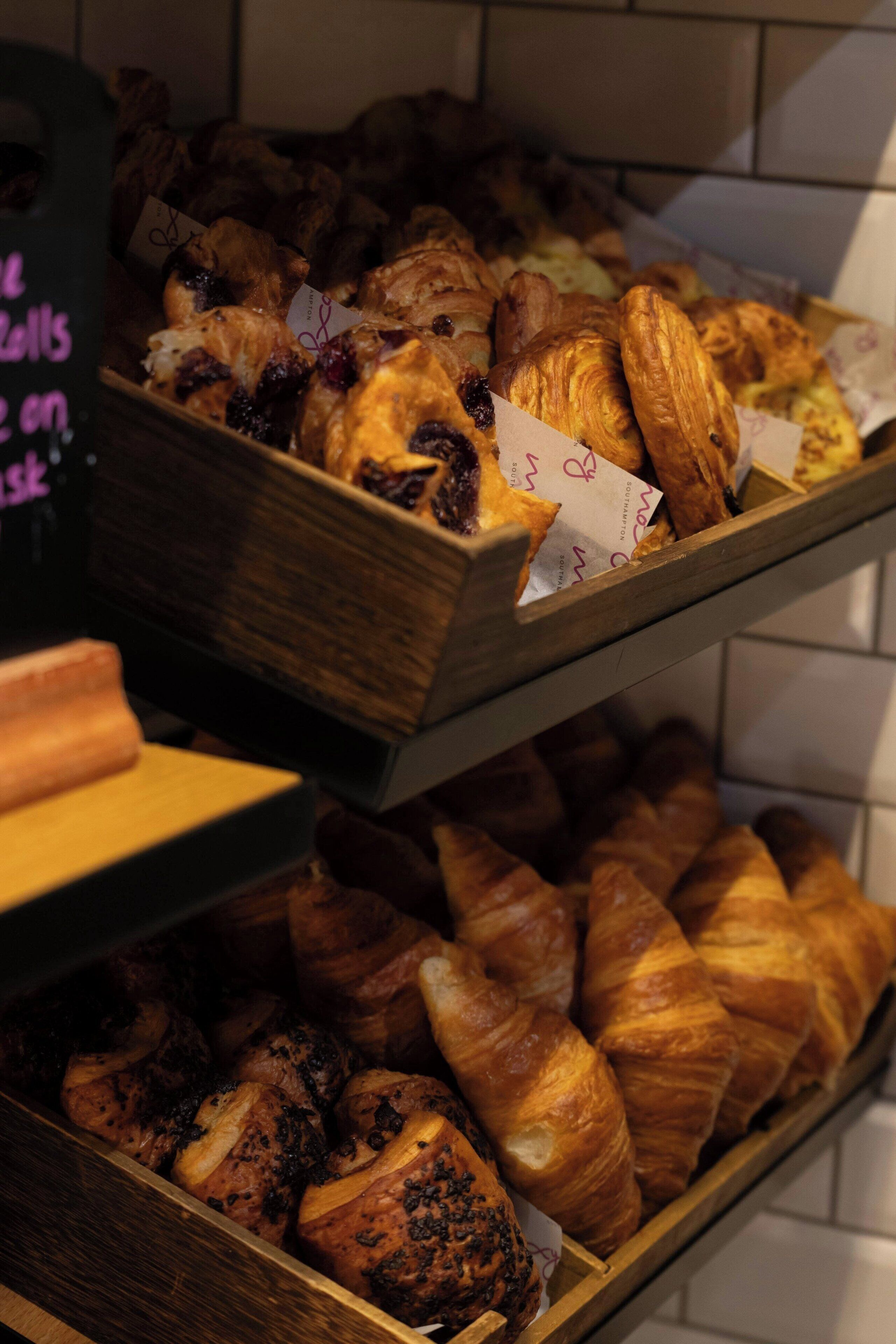 Mostrador de panadería con diversos tipos de pan y pastelería.