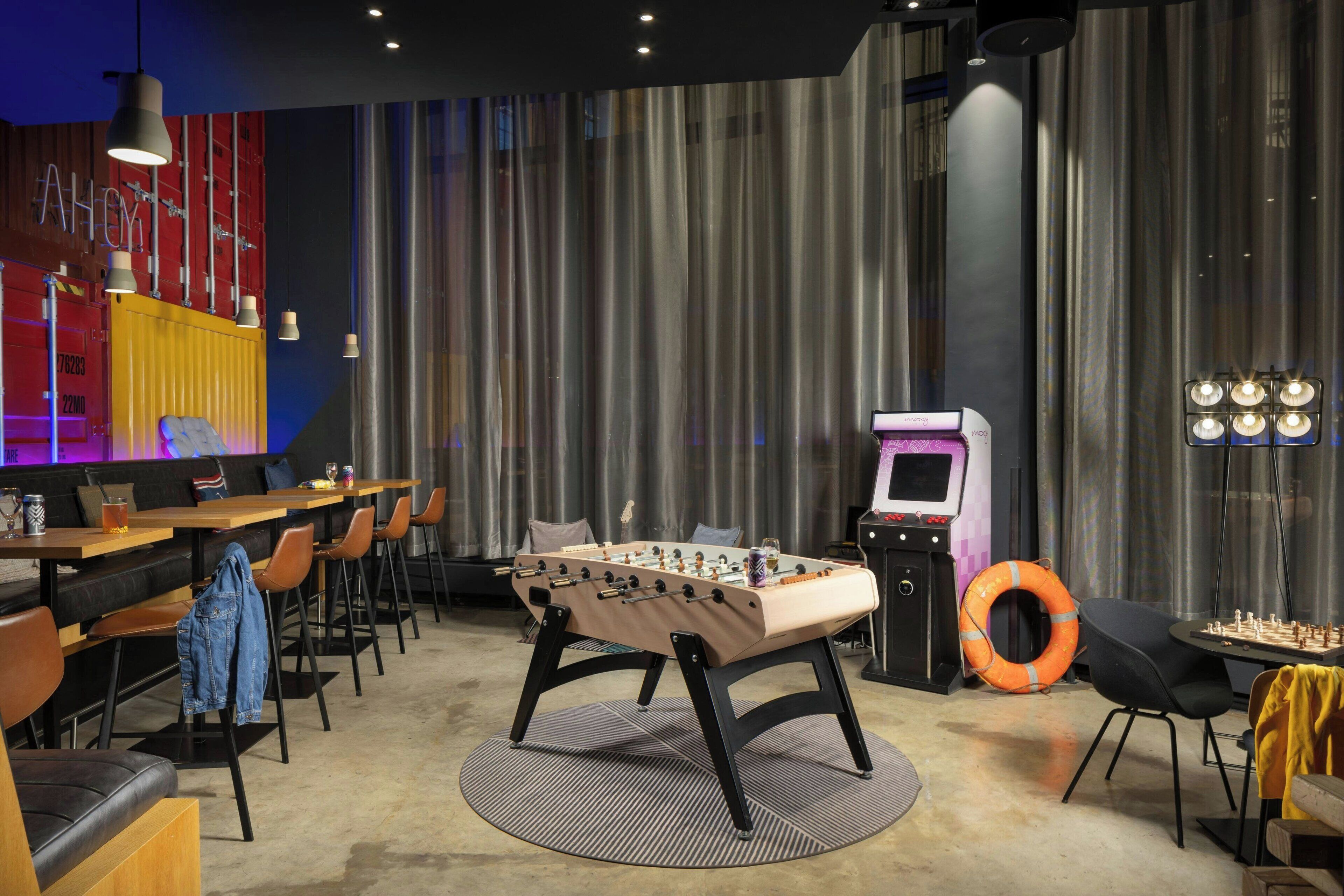 Un espace intérieur moderne doté de trois tables de baby-foot.