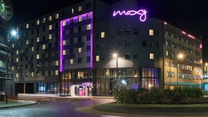 A modern hotel with a neon sign, multiple floors, and a well-lit entrance. - Moxy Southampton (Southampton)