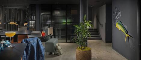 A modern interior with a dining area, a staircase, and a wall mural.