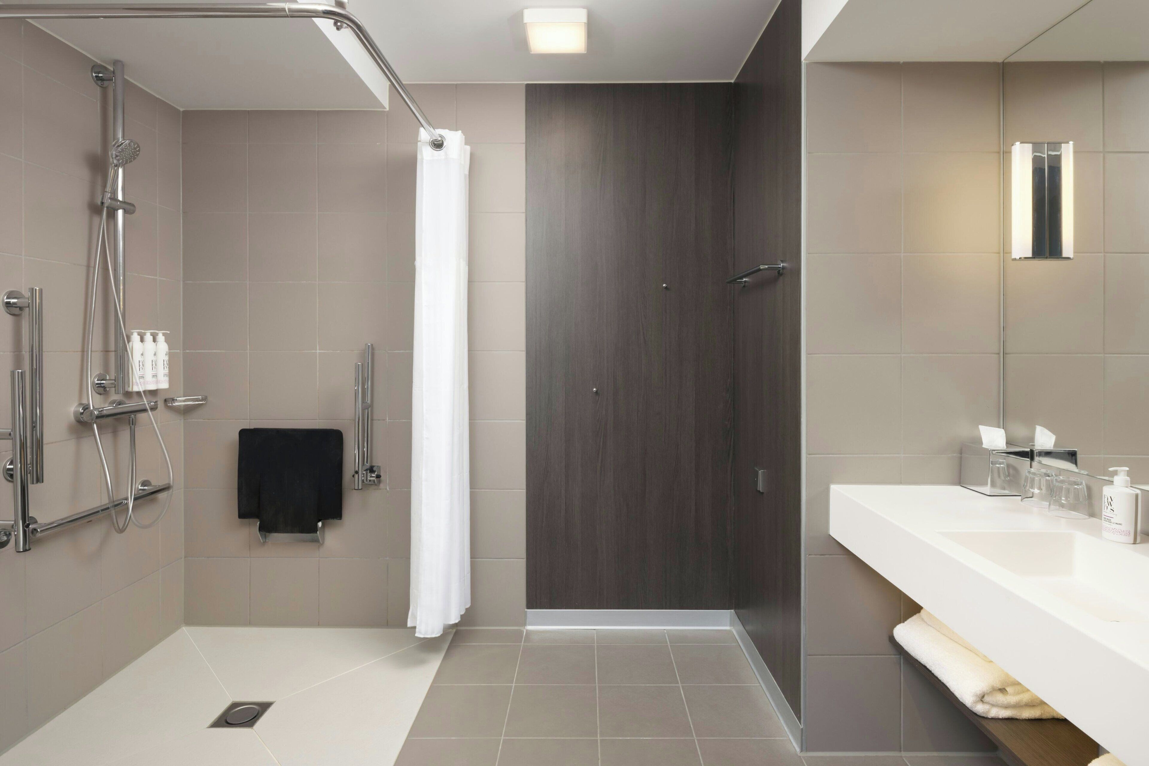 Un baño moderno con ducha, inodoro y lavabo.