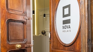 Una puerta de madera con un letrero circular que dice "NOVA RELAIS".