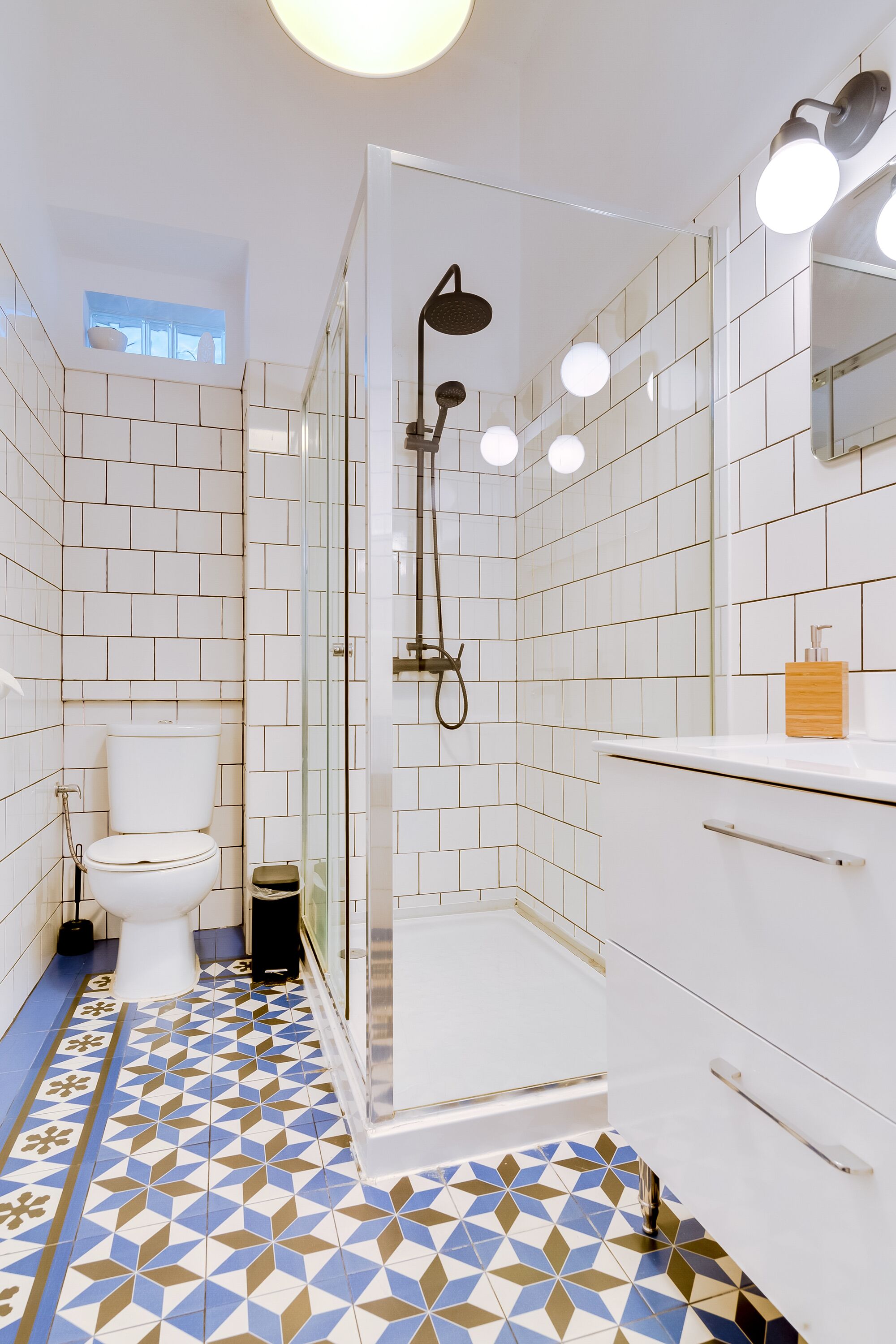 Een moderne badkamer met douche, toilet en wastafel.
