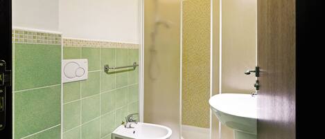A bathroom with a toilet, bidet, and sink.