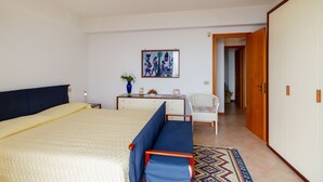 A bedroom with a bed, a desk, a chair, and a wardrobe. - Fontana Vecchia Seaview Apartment  (Taormina)