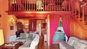A cozy living room with a sofa set, a wooden staircase, and a kitchen area. - Taormina Vintage Loft  (Taormina)