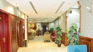 A hotel lobby with a marble floor, wooden doors, and a blue sofa. - Quiet Rooms 3 (Riyadh)
