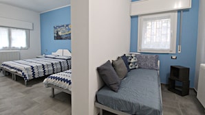 A bedroom with two beds, a window, and a painting on the wall. - R&B San Rafèl (Bologna)