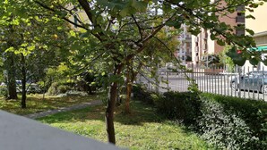 A residential area with trees, a pathway, and a white fence. - R&B San Rafèl (Bologna)