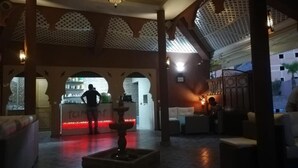 A lobby with a reception desk, seating area, and decorative lighting. - Maison d'hote Dar amghar (Tafraout)