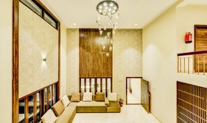 Een modern interieur met een zithoek, een houten accentmuur en een hanglamp.