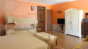 A bedroom with two beds, a wardrobe, a television, and a door. - Villa Rosa B&B (Porto Empedocle)