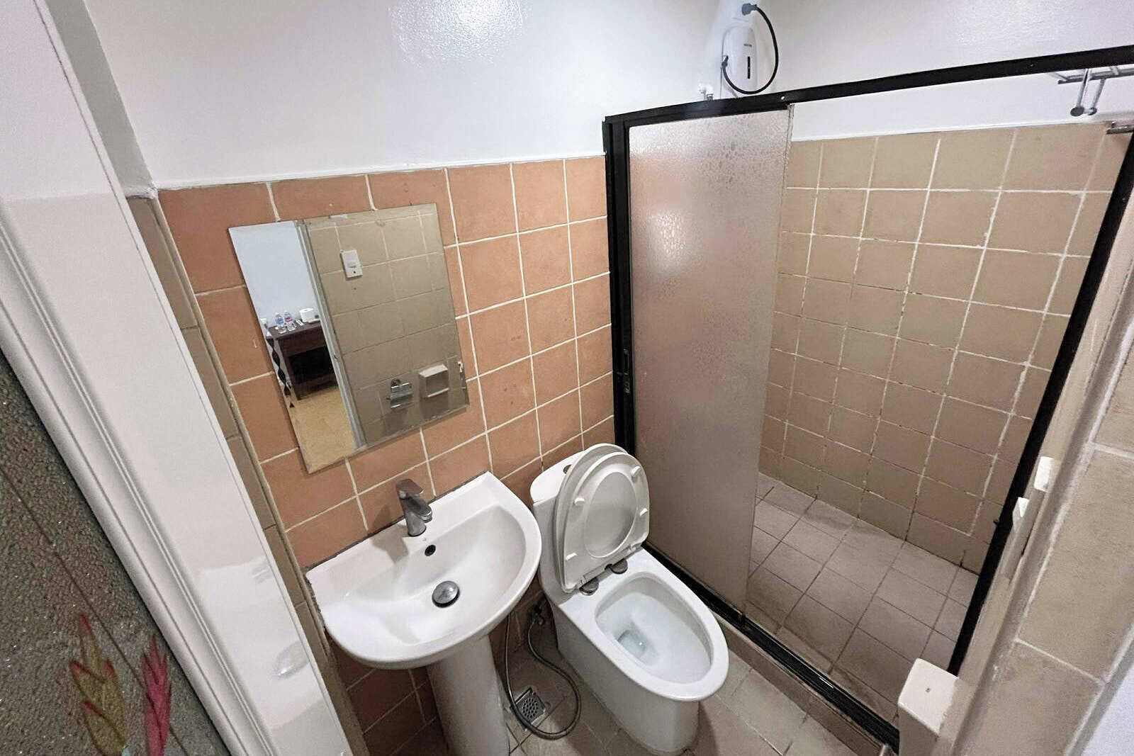 Un baño con lavamanos, inodoro y espejo.