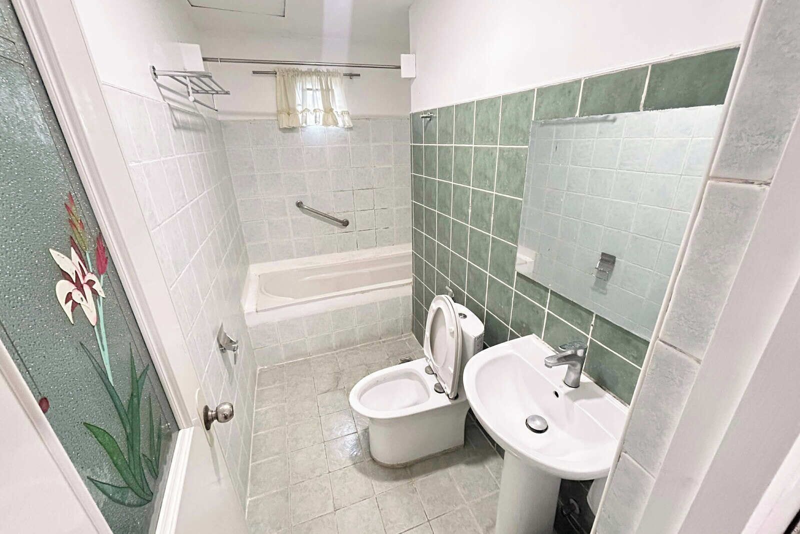 A bathroom with a bathtub, two toilets, a sink, and a shower.