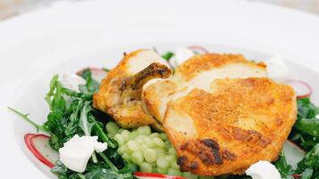 A plate of food with greens, radishes, and a white sauce.