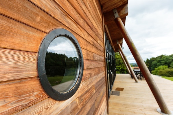 A wooden exterior wall with a circular window.