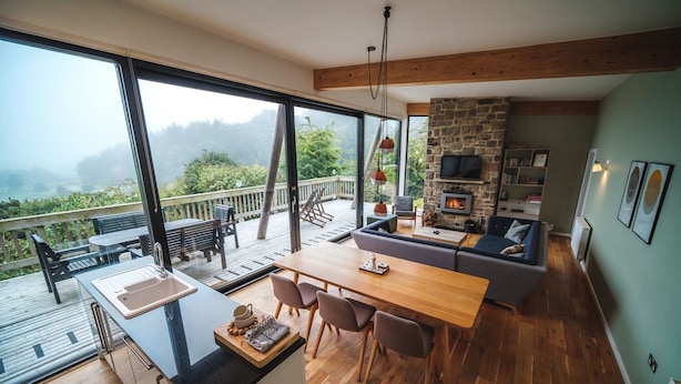 A modern kitchen with a large island, dining area, and a stone fireplace. - A yorkshire dale that sleeps 6 guests  in 3 bedrooms (Richmond)