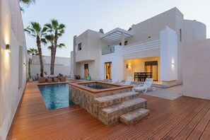 A modern outdoor pool area with a hot tub, wooden deck, and outdoor seating. - Sable de Mirleft (Mirleft)