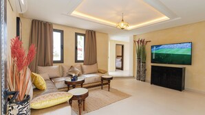 Una sala de estar moderna con sofá, mesa de centro y televisor.