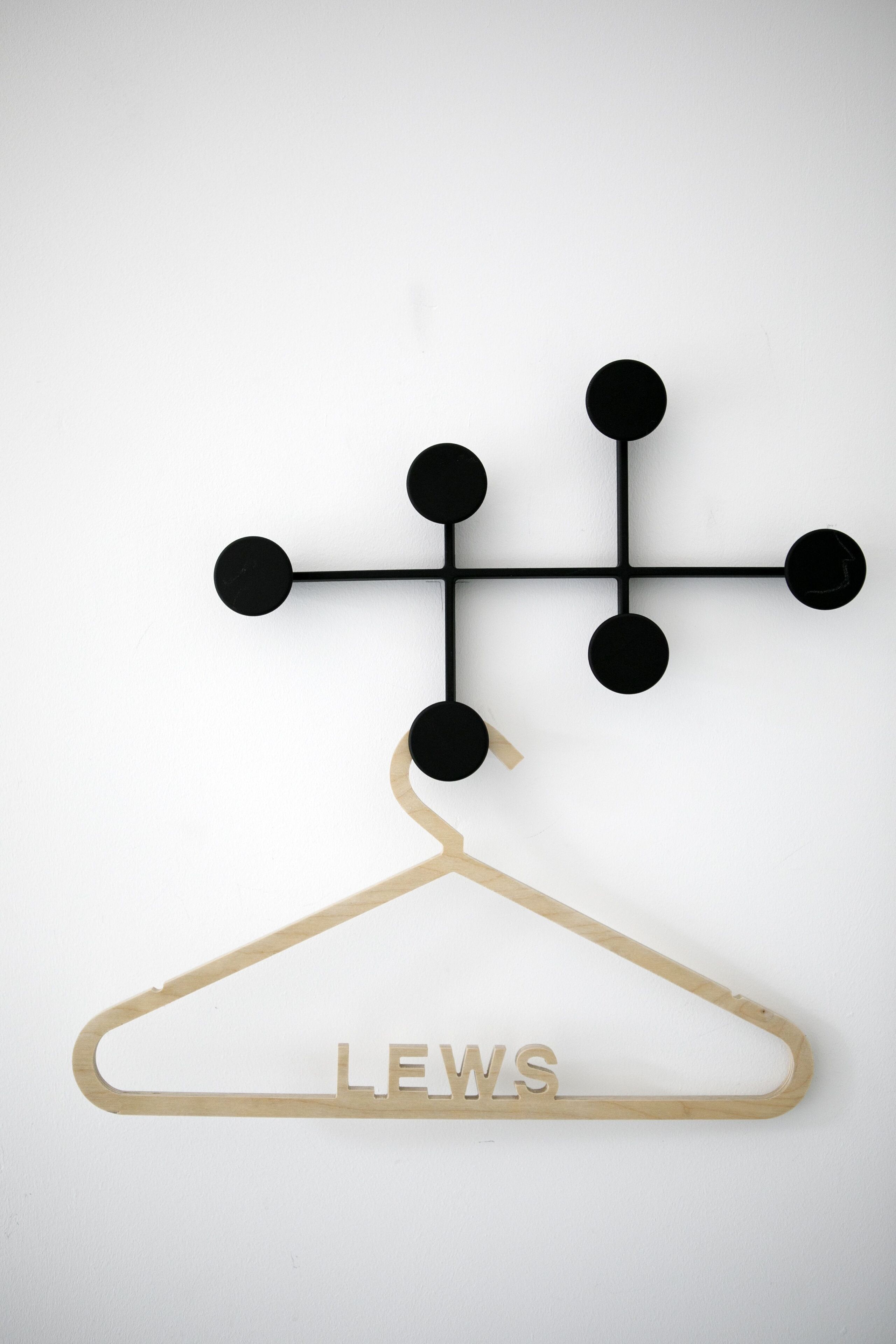Una percha de madera con la palabra "LEWS" escrita.