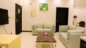 Una sala de estar con sofá, mesa de centro y televisor.