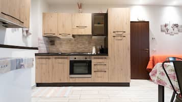 Kjøleskap, ovn, kjøkkenutstyr og spisebord