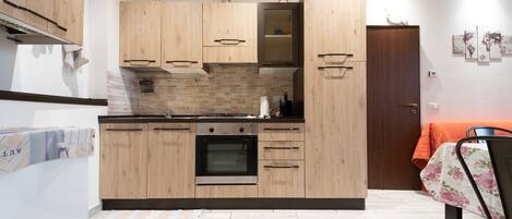 Refrigerador, horno, utensilios de cocina, mesa de comedor