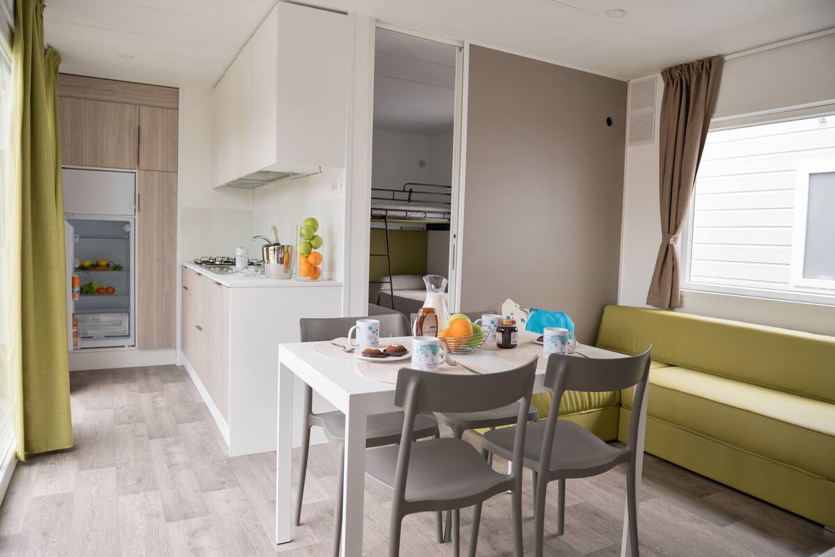 A compact living space with a kitchenette, dining area, and a sofa.