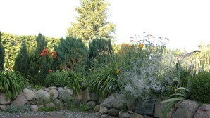 A garden with a stone wall, various plants, and a paved walkway. - 89820 Fw 2 - 89820 Holiday apartment 2 (Malchow)