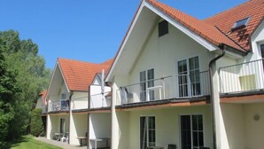 A two-story building with a red-tiled roof, multiple balconies, and outdoor seating areas. - Gollwitzer Park (Insel Poel) by Interhome (Gollwitz (Insel Poel))
