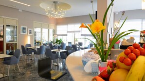 Eine moderne Hotelhalle mit einer gebogenen Rezeption, einer Sitzecke und großen Fenstern.