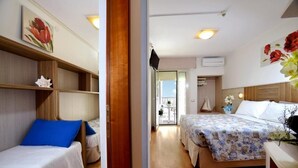 Ein Hotelzimmer mit zwei Betten, Holzboden, einem Balkon und Blick zum Himmel.