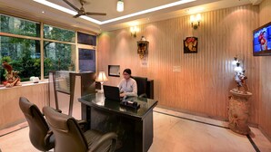 Un bureau bien éclairé, équipé d’un bureau, de chaises et d’un écran de télévision.
