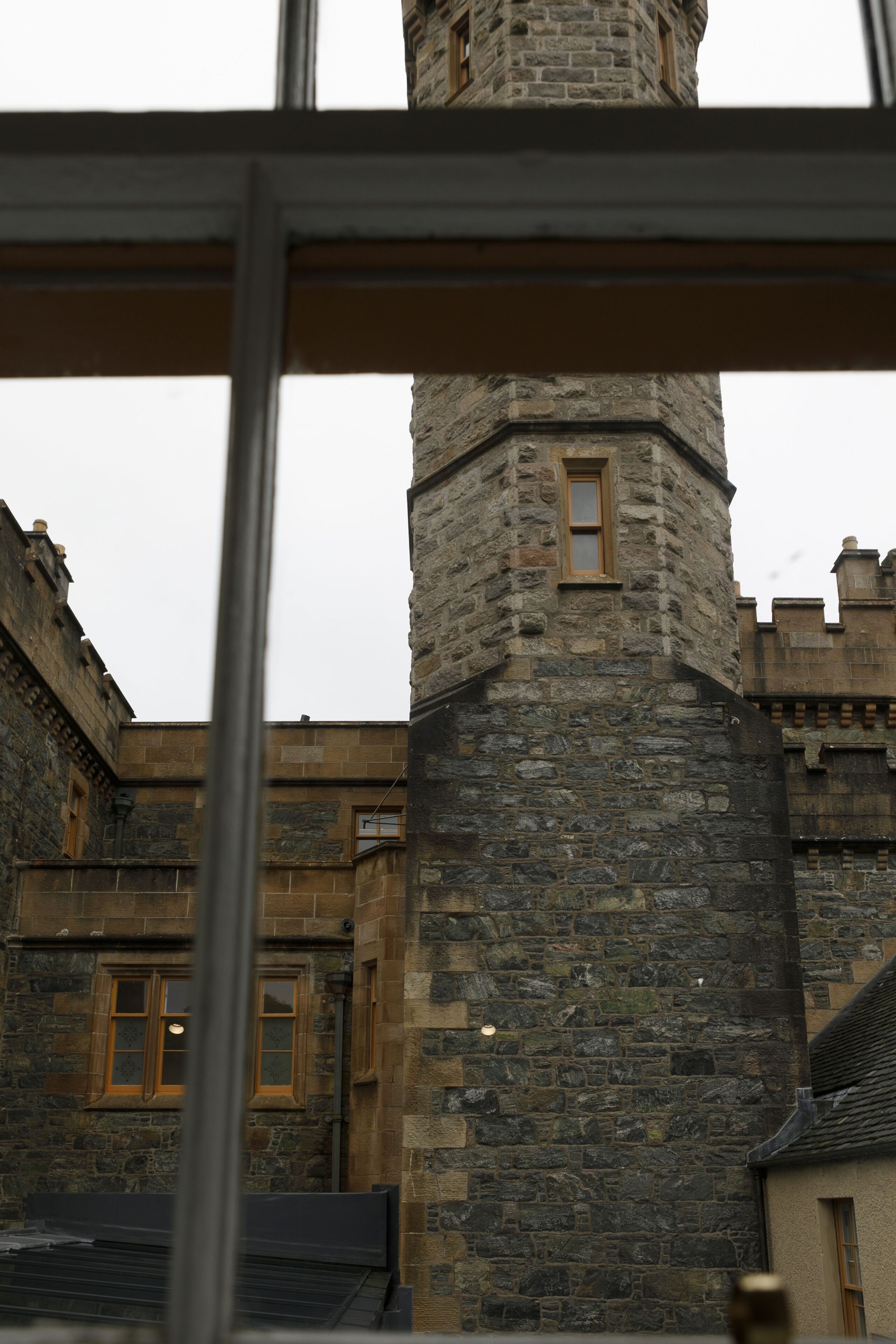 A stone tower with a window, part of a historic building with stone walls and a traditional design.