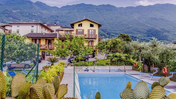 Um hotel com piscina, rodeado por cactos e montanhas.