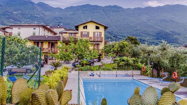 Un hôtel doté d’une piscine, entouré de cactus et de montagnes.