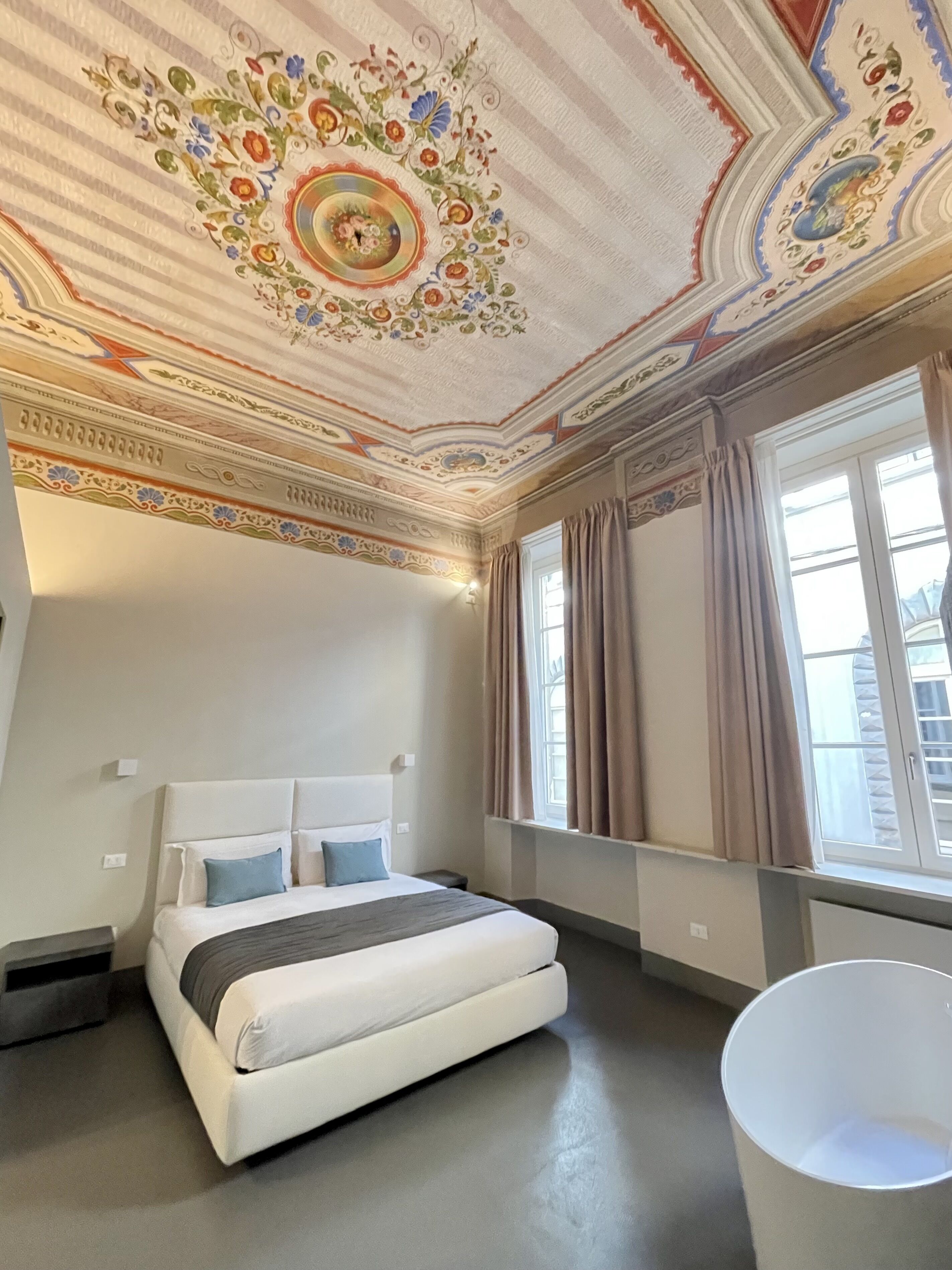 A bedroom with a large bed, a bathtub, and a decorative ceiling.
